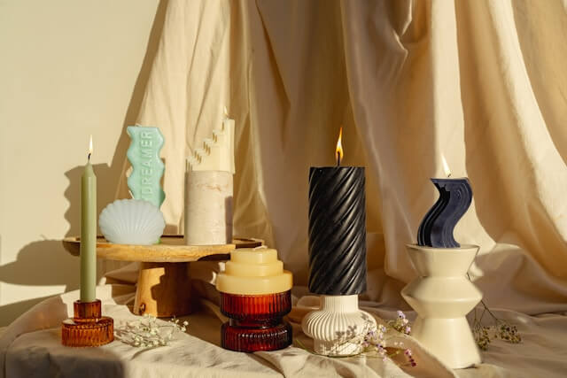 Multiple candles with varied shapes  and colors.