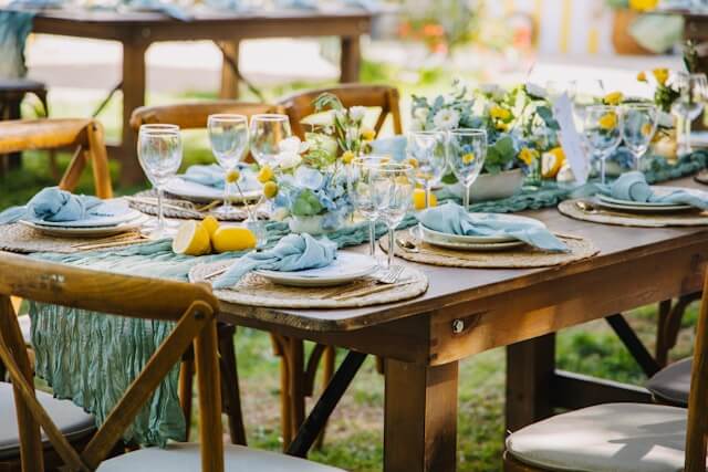 Wood dining table outdoors set with place setting and floral accents