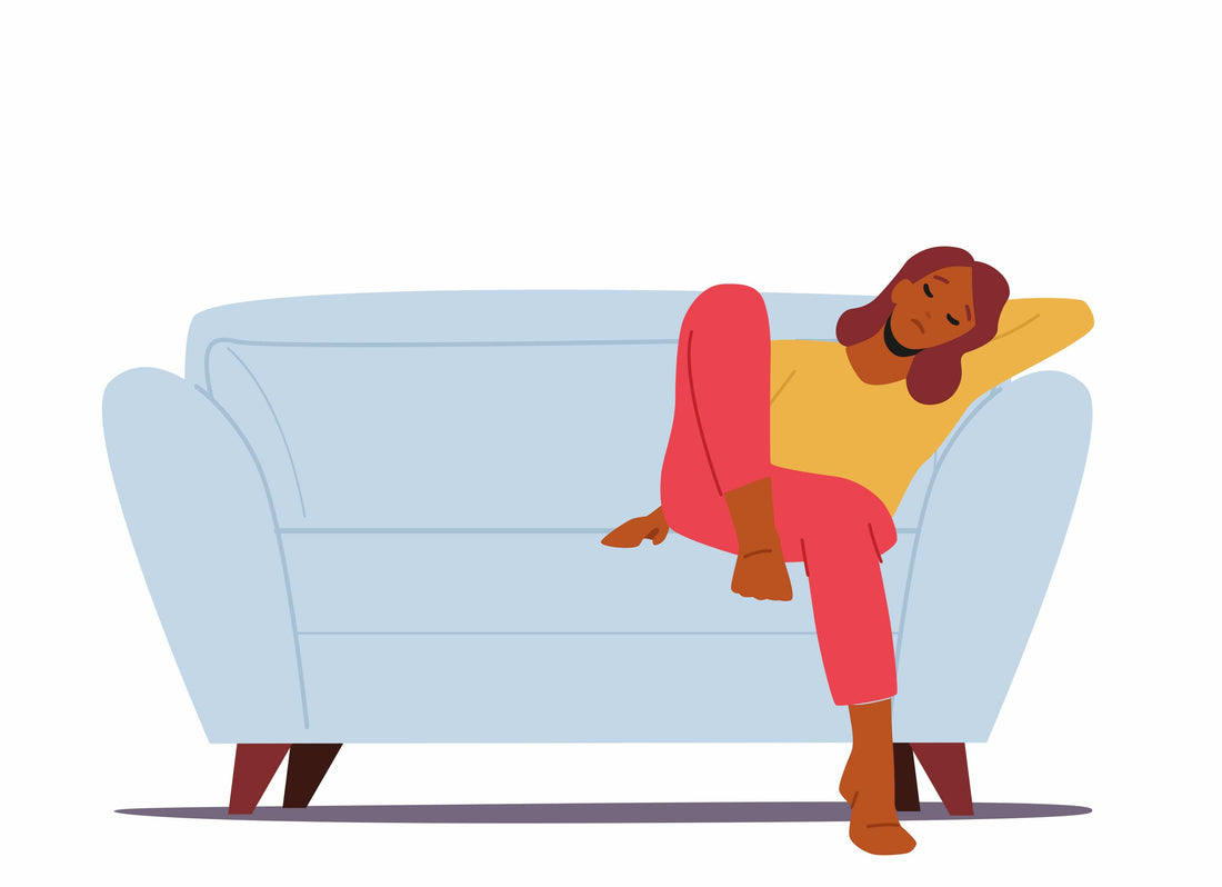 A woman sitting on a blue couch with her eyes closed.