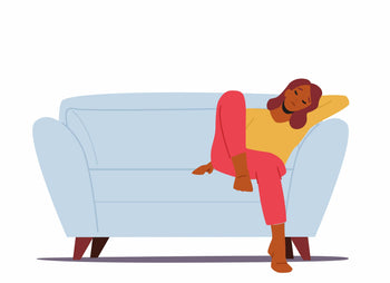 A woman sitting on a blue couch with her eyes closed.