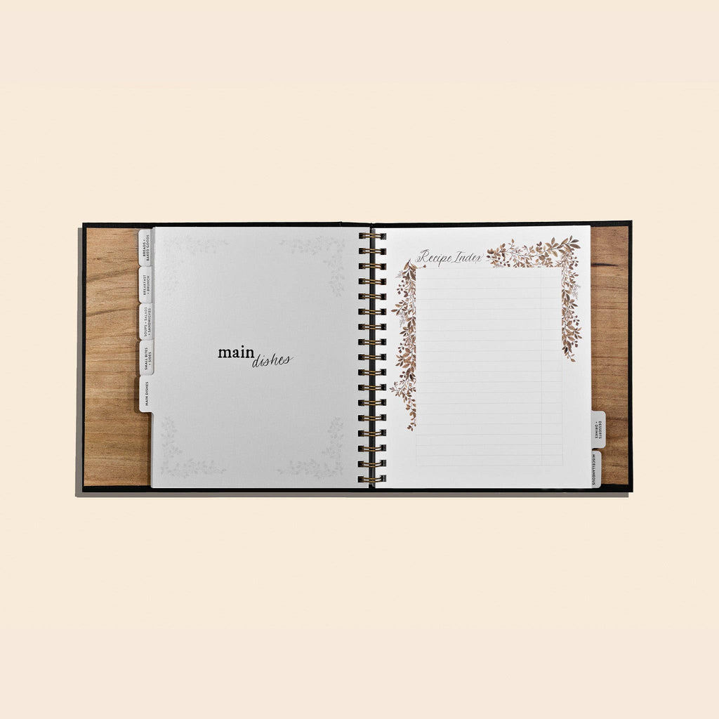 Open recipe book with wooden cover on a beige background