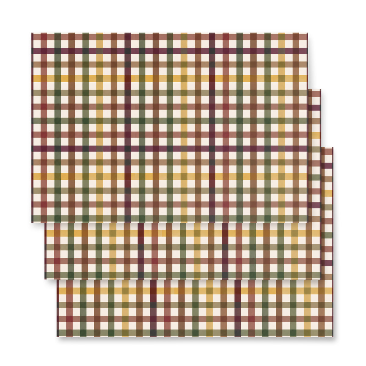 Three rectangular placemats with a plaid pattern in mustard yellow, olive green, and burgundy, stacked diagonally on a white background.