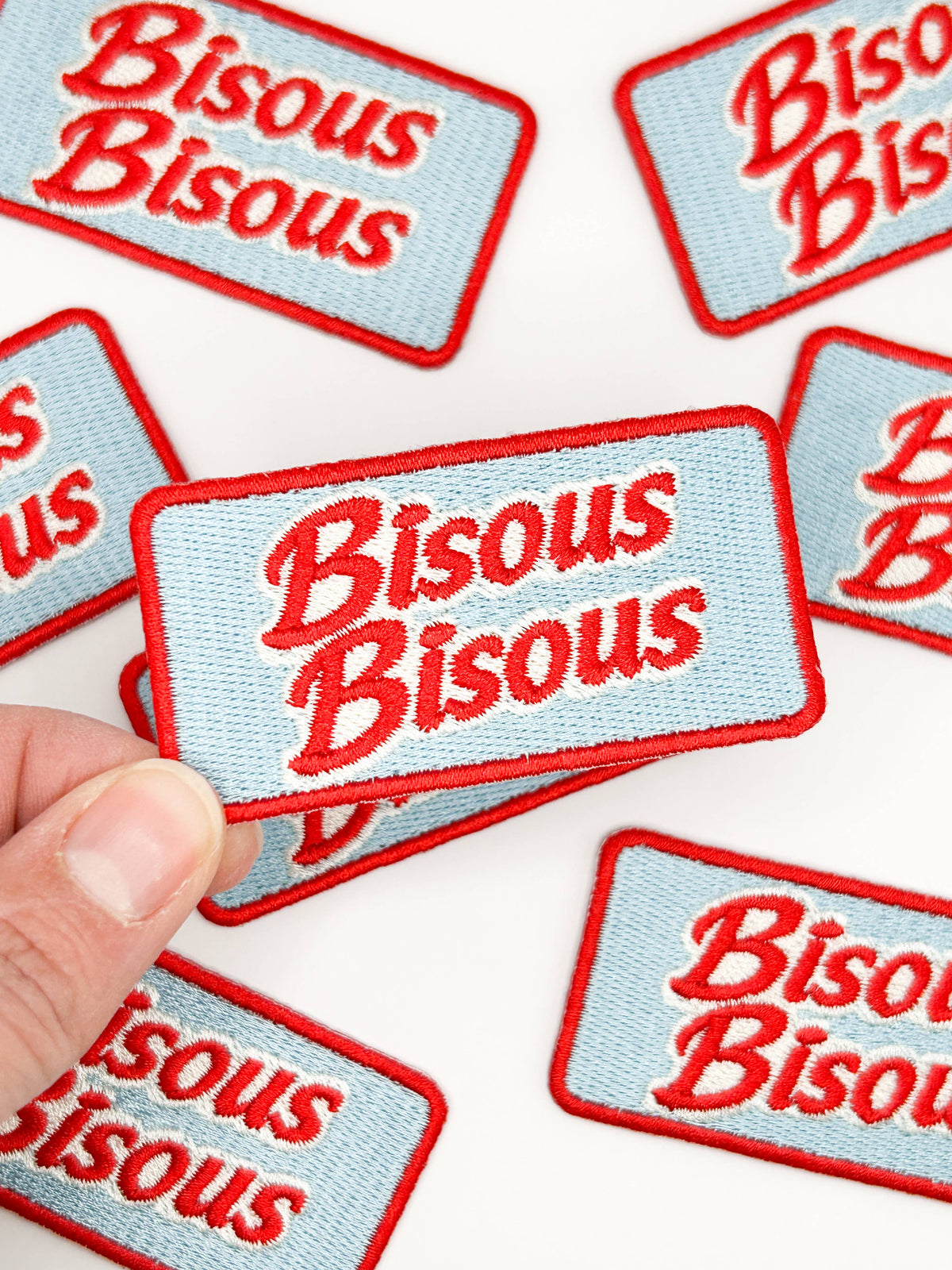 Multiple 'Bisous Bisous' patches with red text on a white background