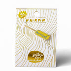 Hairpin packaging with gold and white design on a white background