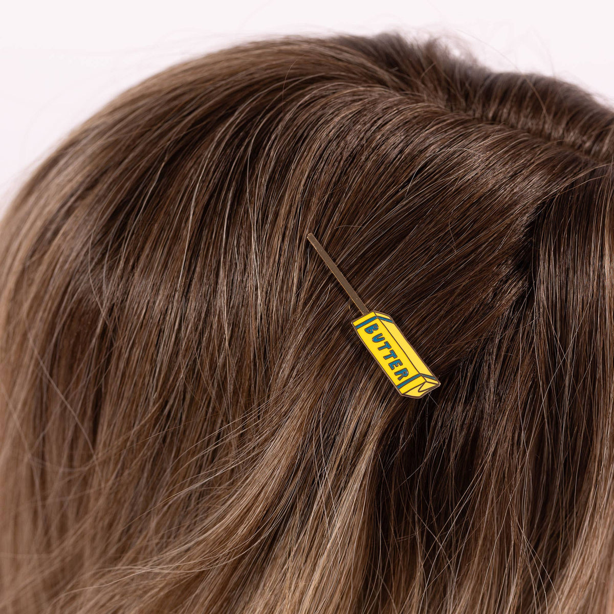 Hair clip with a yellow and black design in brown hair