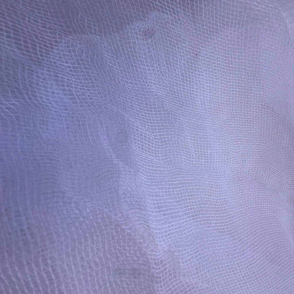 A close-up of a white sheer mesh fabric with a fine grid texture.
