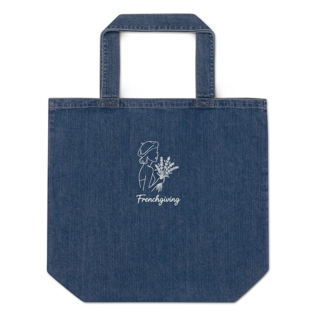 A blue denim tote bag with a white line-art graphic of a woman holding flowers and the text 'Frenchgiving' printed on the front, set against a plain white background.