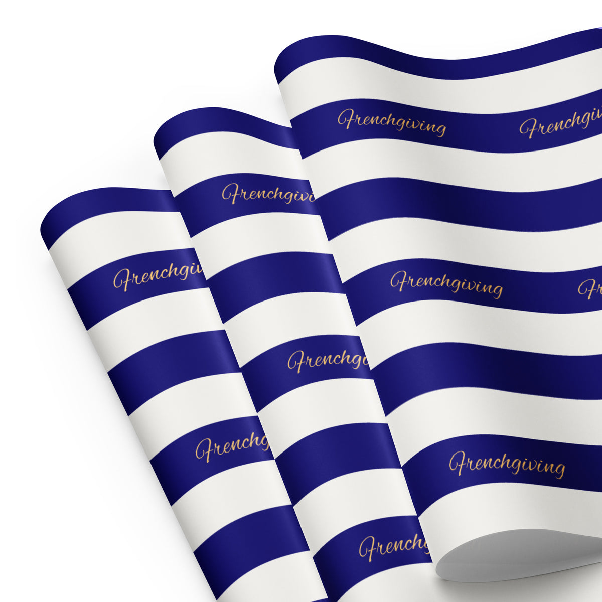 Three rolled sheets of wrapping paper with horizontal navy blue and white stripes, featuring the word 'Frenchgiving' printed in gold script along the blue stripes, set against a plain white background.