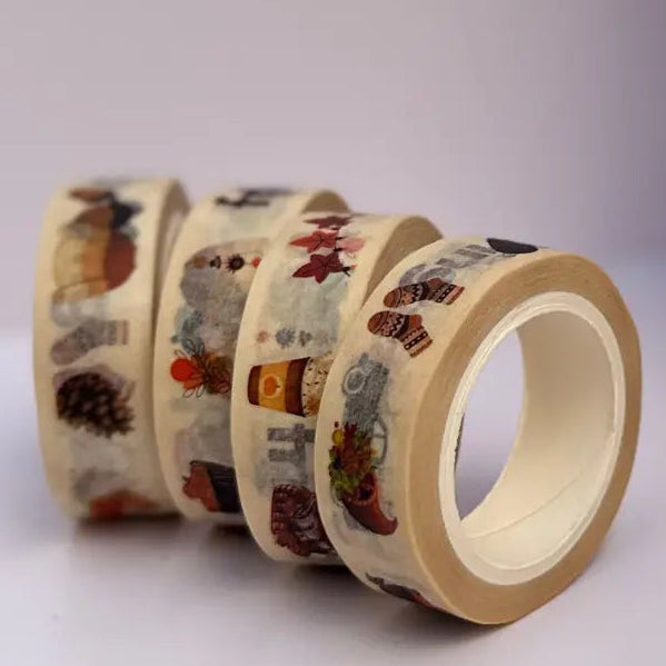 Four rolls of patterned washi tape displayed on a white surface, with one roll unrolled to show the design. The tape features a Friendsgiving holiday theme with illustrations of turkeys, pumpkins, and autumn elements on a cream background.