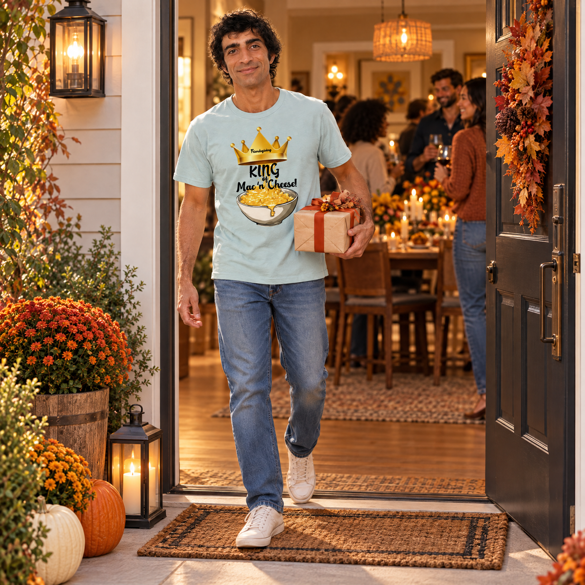 Man carrying package to holiday party wearing a tshirt with a bowl of mac 'n cheese on it with the text "King of Mac 'n Cheese"