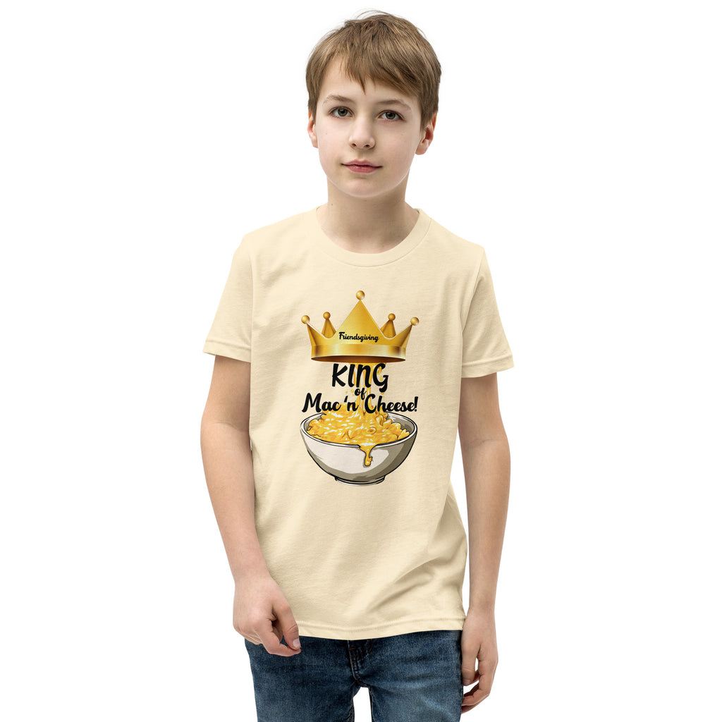 Child wearing a cream t-shirt with 'King of Mac n Cheese' graphic design on a white background