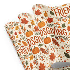 A roll of wrapping paper with a festive autumn pattern featuring pumpkins, leaves, acorns, and berries, printed with the words 'FRIENDLY GIVING' in orange-brown script on a cream background.