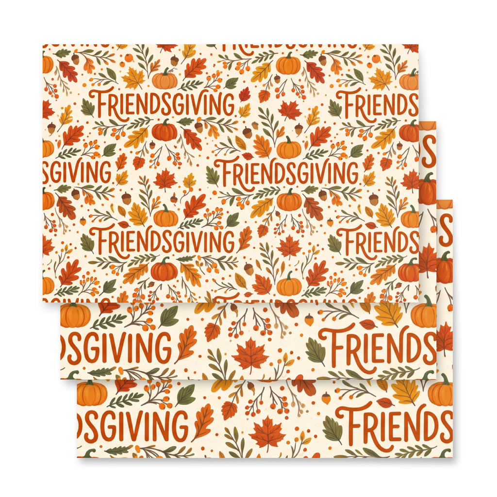 Three stacked square paper napkins with a festive Thanksgiving pattern featuring pumpkins, autumn leaves, acorns, and the word 'FRIENDSGIVING' repeated across an off-white background.