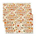 Three stacked square paper napkins with a festive Thanksgiving pattern featuring pumpkins, autumn leaves, acorns, and the word 'FRIENDSGIVING' repeated across an off-white background.