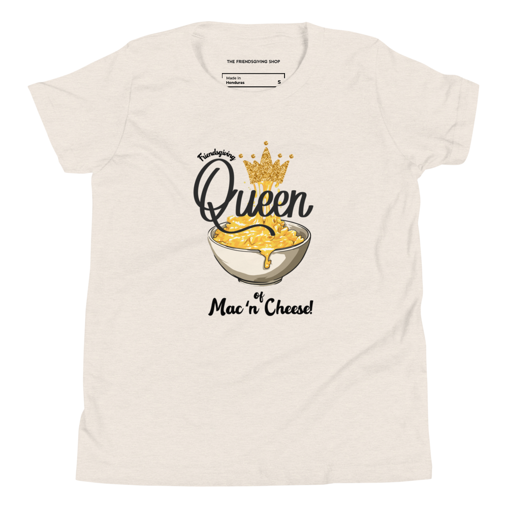 A heather dust t-shirt with a graphic print of a bowl of mac and cheese topped with a gold crown, featuring the text 'Queen of Mac'n Cheese!'. The inner collar label shows the brand 'The Friendsgiving Shop'.