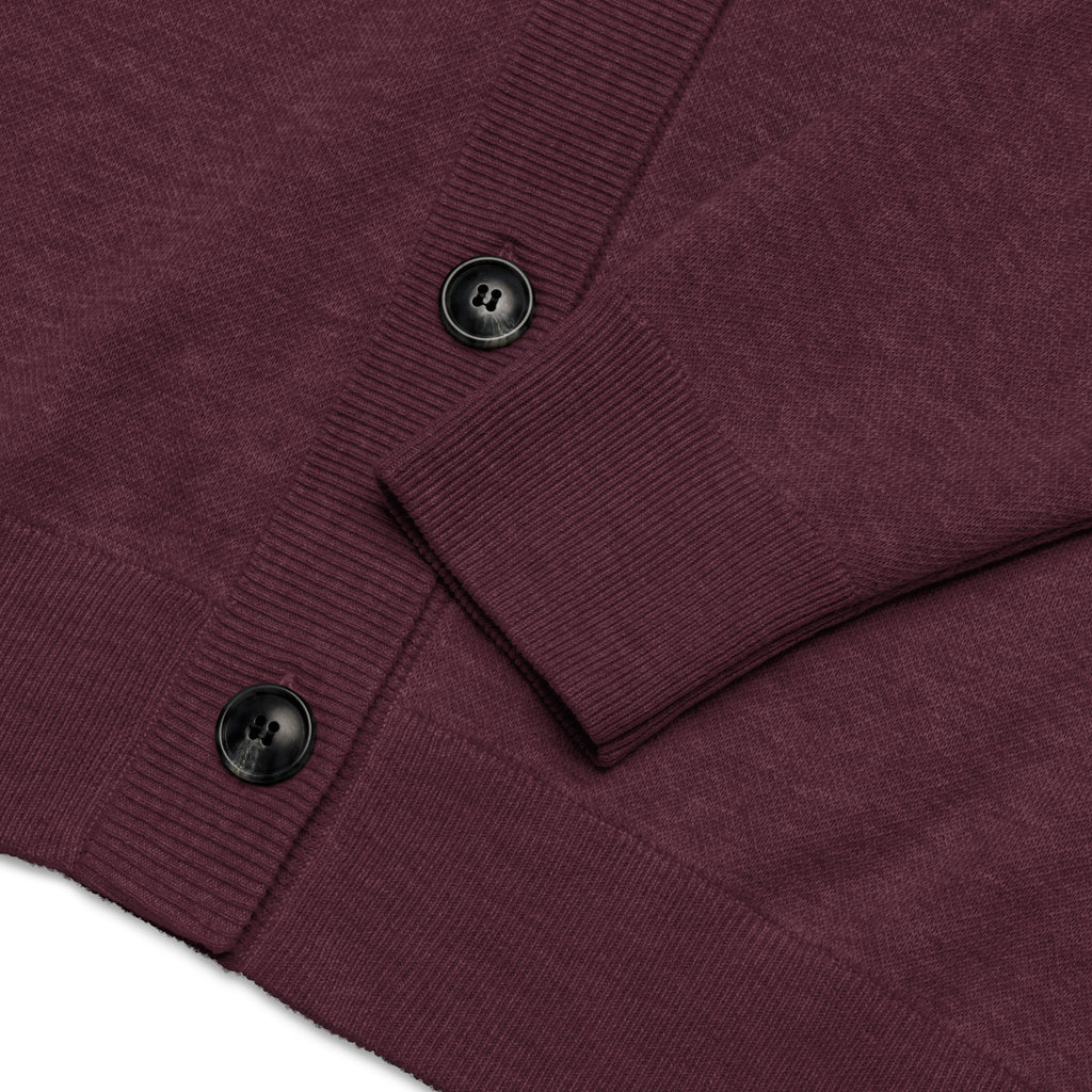 Close-up of a ribbed knit cardigan in deep burgundy with black buttons, showing the sleeve cuff and front placket detail.