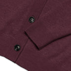 Close-up of a ribbed knit cardigan in deep burgundy with black buttons, showing the sleeve cuff and front placket detail.