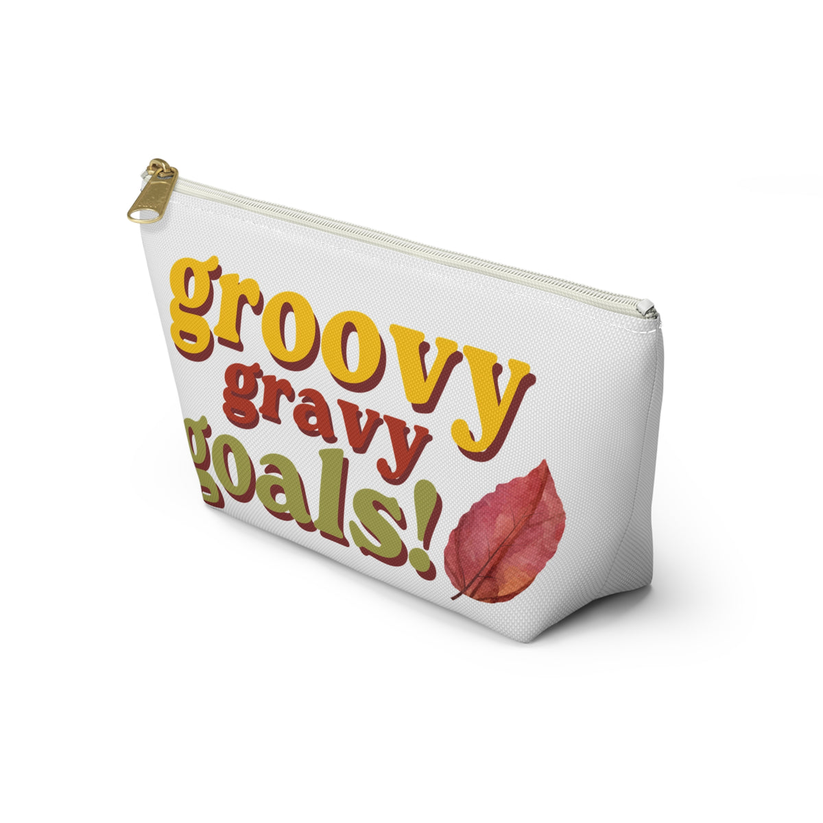 A white zippered pouch with a retro-style graphic reading 'groovy gravy goals!' in yellow, red, and olive green lettering, accompanied by a red leaf illustration and a gold zipper pull, shown on a white background.