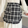 Person wearing a black and white plaid skirt with a blurred background