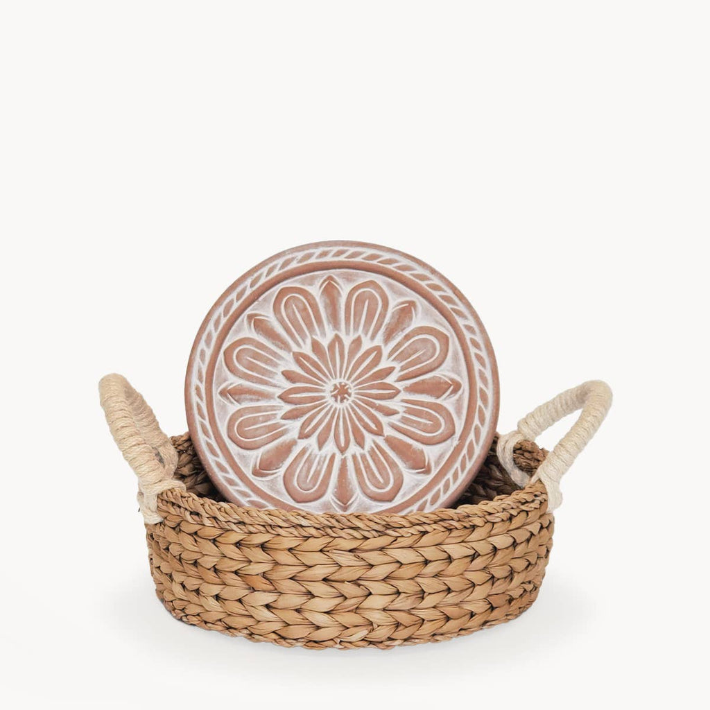 Decorative ceramic plate with floral design in a woven basket on a white background