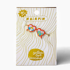 A 18K gold-plated heart-shaped hair pin by Yellow Owl Workshop, shown on its white and gold patterned retail backing card.