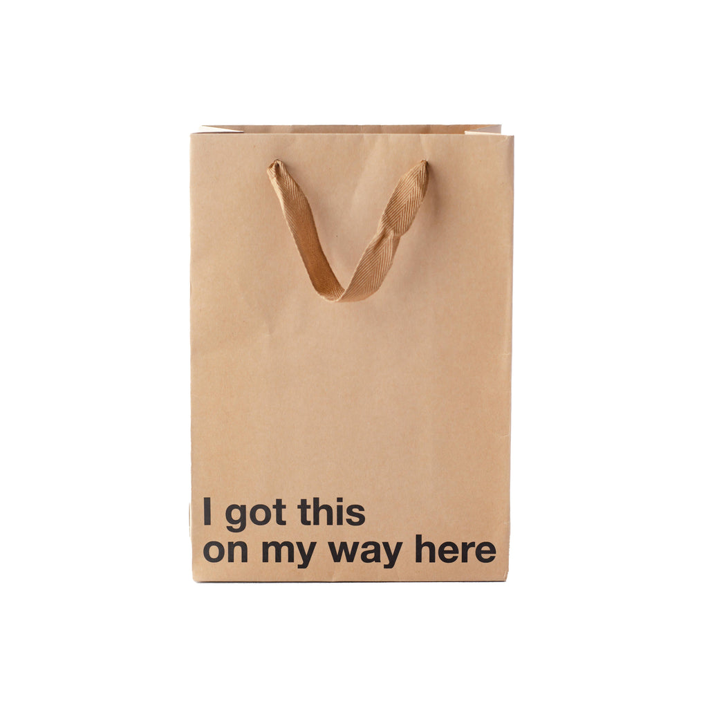 Brown paper bag with 'I got this on my way here' text on a white background