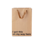 Brown paper bag with 'I got this on my way here' text on a white background