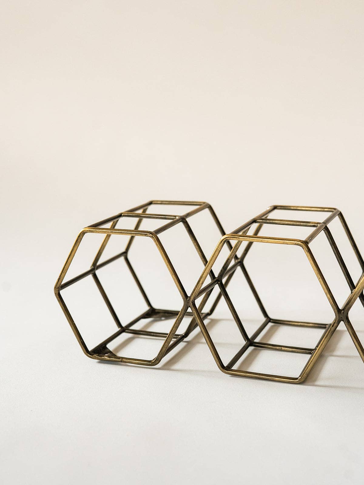 Two brass geometric wire cube planters on a clean white background.
