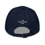 A navy blue baseball cap shown from the back, featuring the white embroidered text 'THE FRIENDSGIVING SHOP' on the back panel and an adjustable dark metal buckle strap.