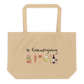 Beige tote bag with 'le friendsgiving' text and food illustrations on a white background