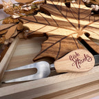 A wooden serving utensil set in a light wood gift box, featuring a leaf-shaped wooden board engraved with leaf veins and a matching wooden-handled serving fork engraved with 'Give Thanks' on the handle.