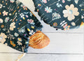 Floral-patterned fabric with a baguette on a wooden surface