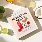 Book titled 'Mocktail Party' with cocktail illustrations on a light surface with limes and a coconut.