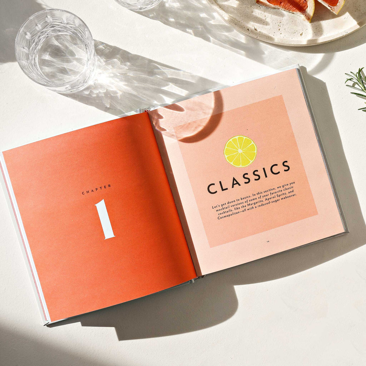 Open book with 'Classics' chapter on a light surface with a glass and plate in the background