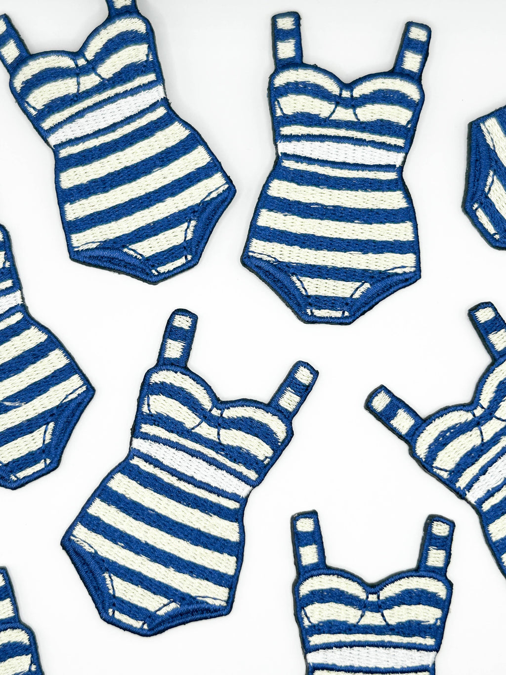 Pattern of blue and white striped swimsuits on a white background