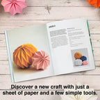 Open book with paper craft instructions on a wooden surface