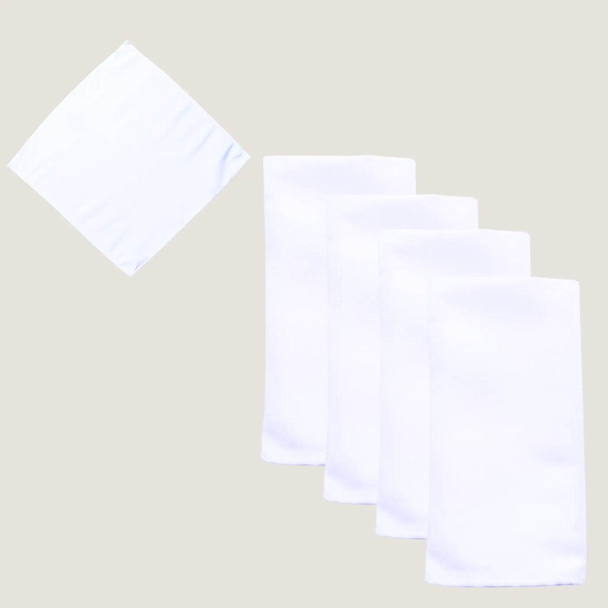 Four white fabric napkins, with three folded and stacked and one unfolded showing its square shape, on a light beige background.