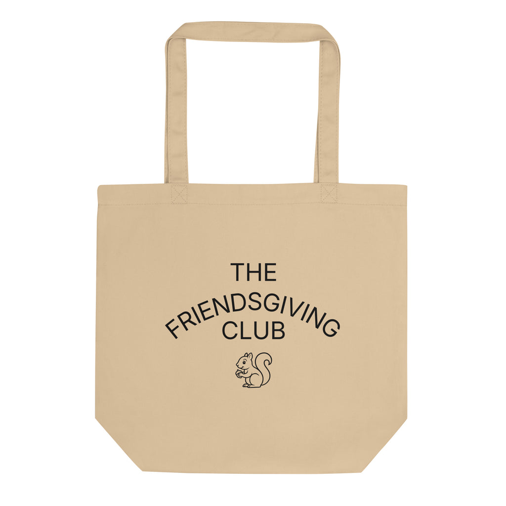 A beige canvas tote bag with black printed text reading 'THE FRIENDSGIVING CLUB' and a small squirrel illustration on the front, shown against a plain white background.