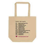 A beige canvas tote bag with black printed text listing 'SAVE THE DATE' dates and a small pink heart logo at the bottom, shown on a plain white background.