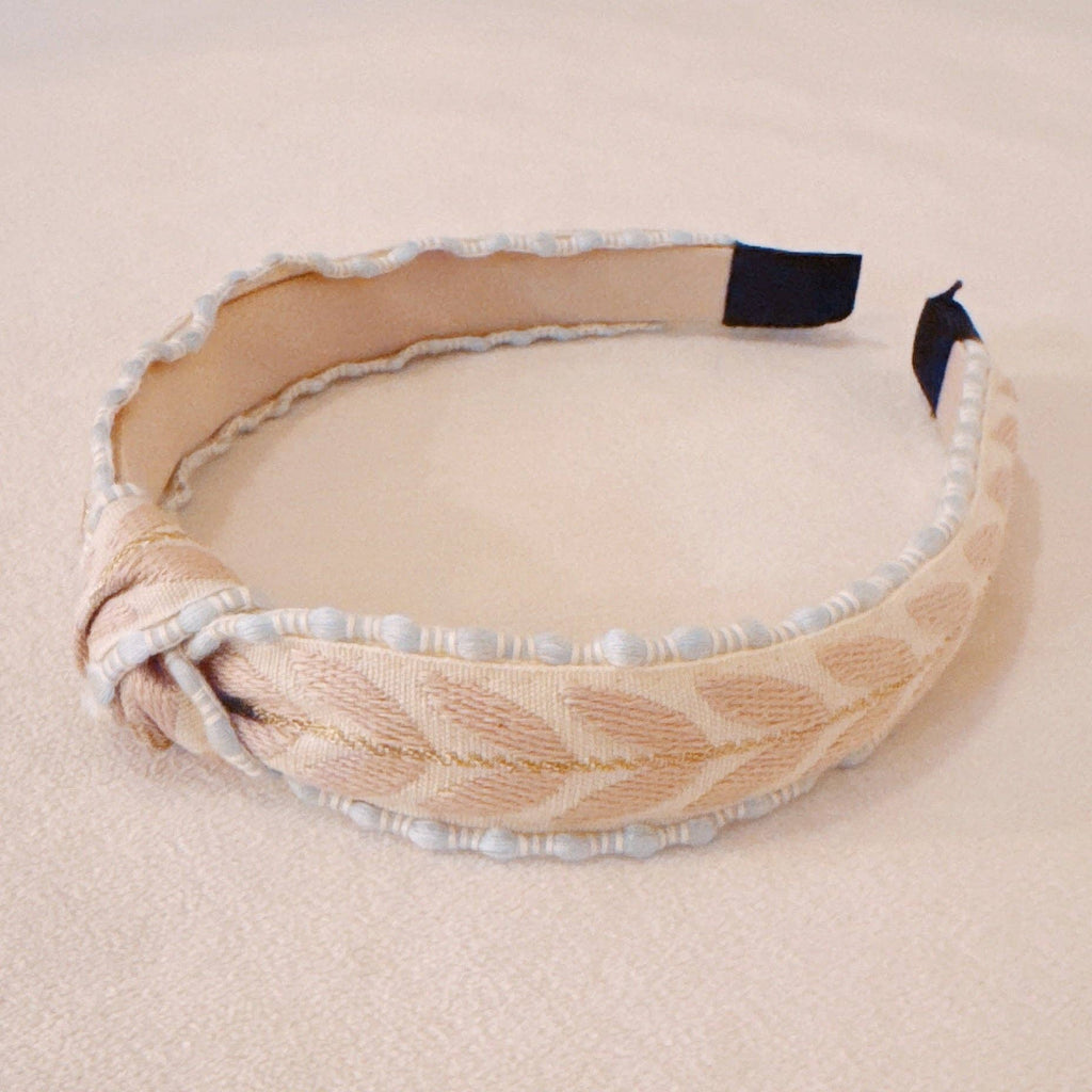 Beige headband with decorative elements on a beige background