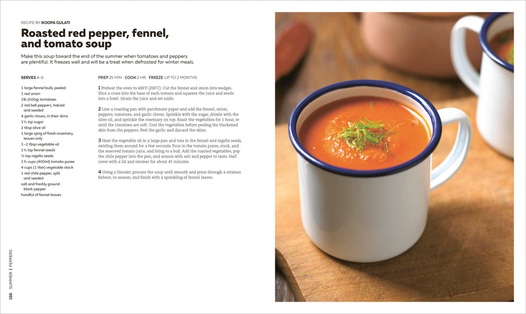 White mug with blue rim filled with roasted red pepper, fennel, and tomato soup on a wooden surface.