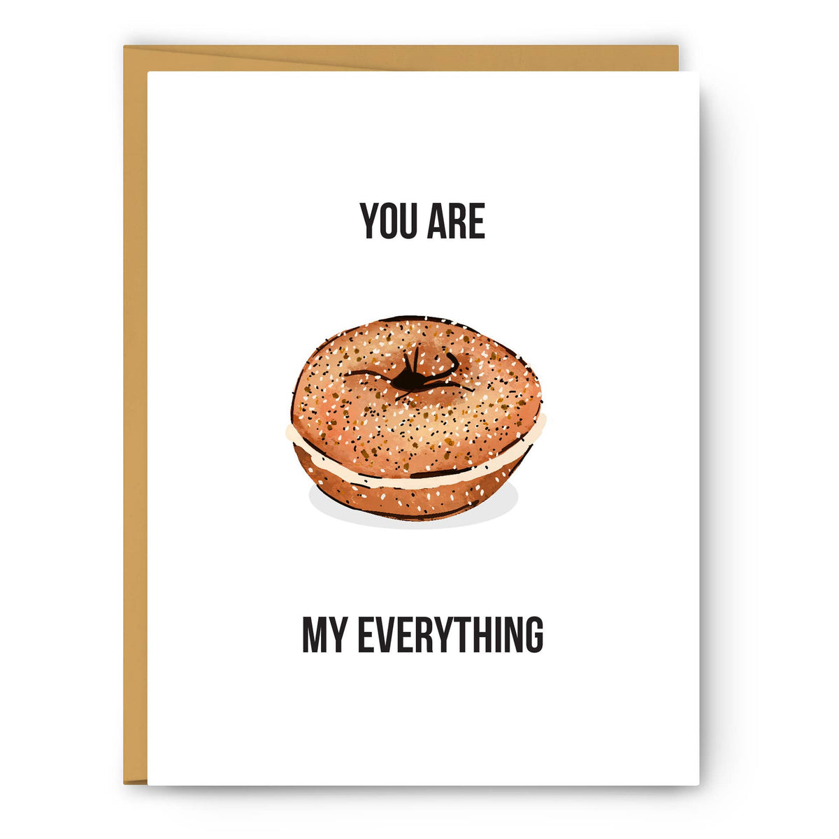 A white greeting card with a gold envelope behind it, featuring a watercolor-style bagel with cream cheese and the text 'YOU ARE MY EVERYTHING' in black.